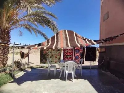 a table and chairs in front of a building at Dar dyafa in Oulad Akkou
