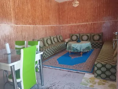 a living room with a couch and a table and chairs at Dar dyafa in Oulad Akkou