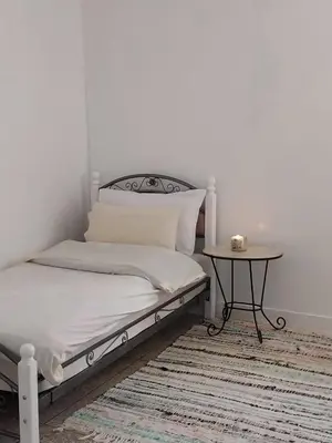a bedroom with a bed and a table on a rug at Gite Montana in Aïn Leuh