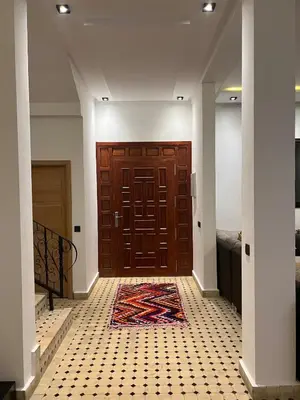 a hallway with a wooden door and a rug on the floor at Villa Yassin Private Pool and Terrace in Marrakech