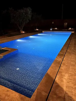 a swimming pool lit up at night with at Villa Yassin Private Pool and Terrace in Marrakech