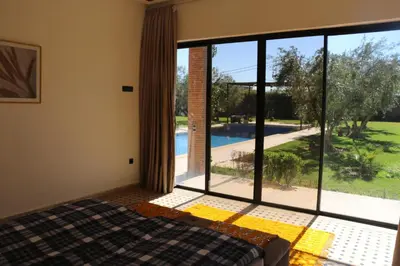 a bedroom with a large window with a view of a pool at Villa Yassin Private Pool and Terrace in Marrakech