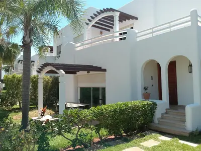 a white house with a palm tree in the yard at فيلا بالصخيرات in Oulad Akkou