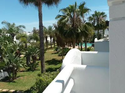 a view from a balcony of a resort with palm trees at فيلا بالصخيرات in Oulad Akkou