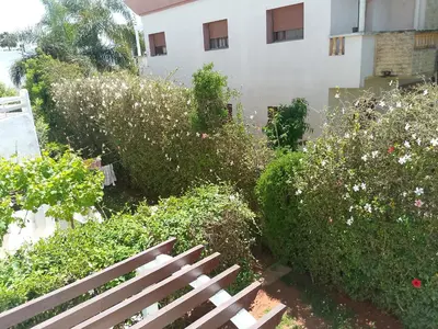 a bench in a garden next to a building at فيلا بالصخيرات in Oulad Akkou