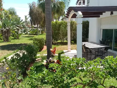 a garden with a table and a palm tree at فيلا بالصخيرات in Oulad Akkou