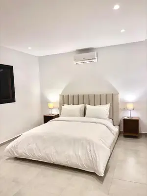 a bedroom with a large white bed with two lamps at Villa Elysia in Chaibate