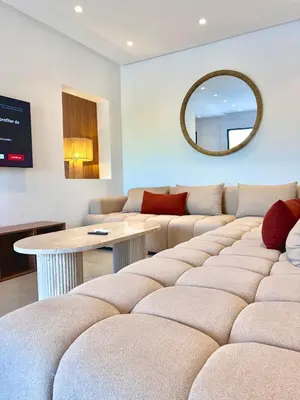 a living room with a couch and a table and a mirror at Villa Elysia in Chaibate