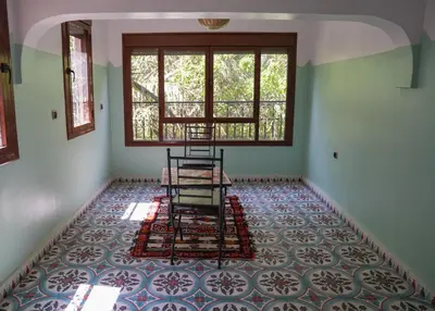 an empty room with two chairs and a window at Tabourihte Gardens in Tinerhir