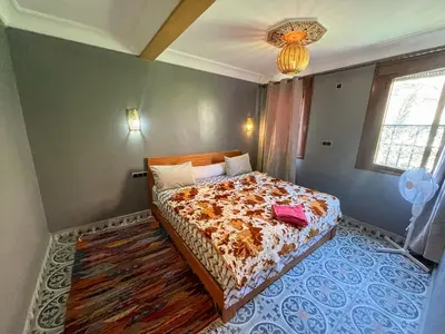 a bedroom with a bed and a chandelier at Tabourihte Gardens in Tinerhir