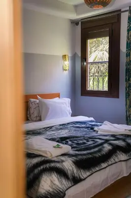 a bedroom with a large bed with a window at Tabourihte Gardens in Tinerhir