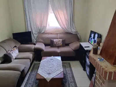 a living room with a couch and a table at Le jardaine d'Ifrane in Oulad Akkou