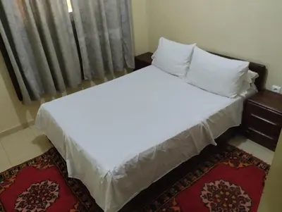 a bed with white sheets and pillows in a room at Le jardaine d'Ifrane in Oulad Akkou