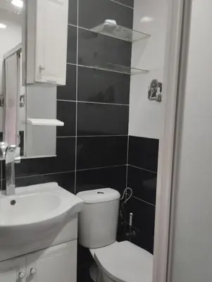 a bathroom with a white toilet and a sink at Le jardaine d'Ifrane in Oulad Akkou