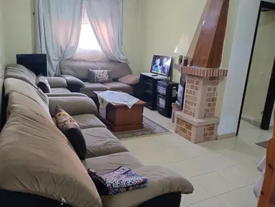 a living room with a couch and a fireplace at Le jardaine d'Ifrane in Oulad Akkou