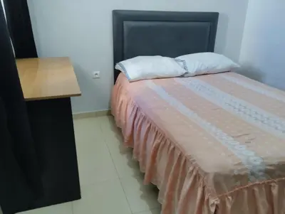 a bedroom with a bed and a wooden table at Le jardaine d'Ifrane in Oulad Akkou