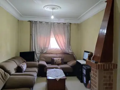 a living room with a couch and a window at Le jardaine d'Ifrane in Oulad Akkou