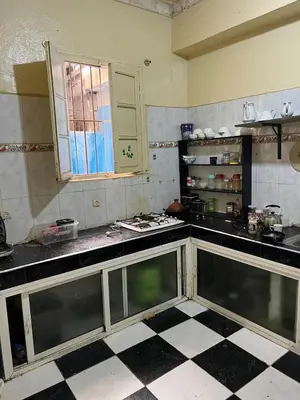 a kitchen with black and white tiled counters and a window at Appartement 135 m spacieux in Oulad Akkou