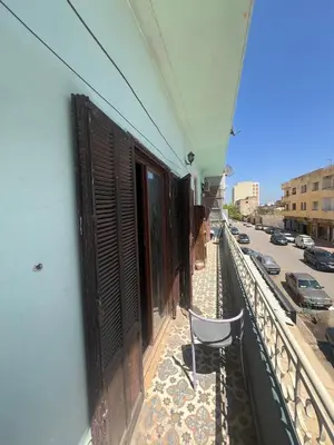 a chair sitting on the balcony of a building at Appartement 135 m spacieux in Oulad Akkou