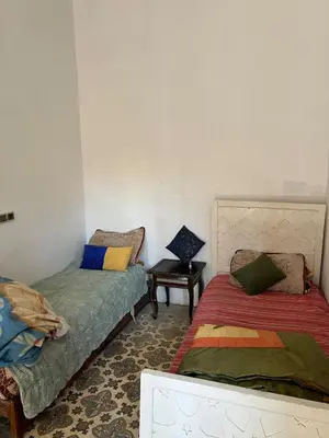 a room with two beds and a table in it at Appartement 135 m spacieux in Oulad Akkou