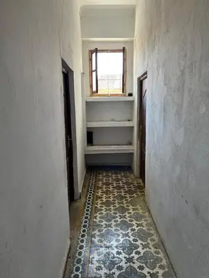 an empty hallway with a window and a tile floor at Appartement 135 m spacieux in Oulad Akkou