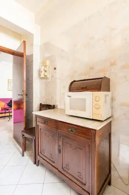 a microwave on top of a wooden cabinet in a kitchen at Bel appartement in Oulad Akkou