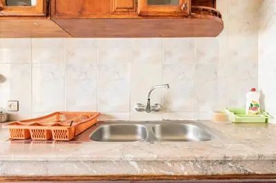 a kitchen sink with an orange basket next to it at Bel appartement in Oulad Akkou