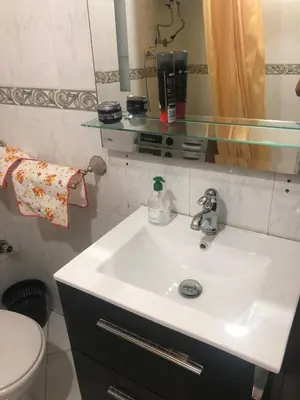 a bathroom with a sink and a toilet and a mirror at Bel appartement in Oulad Akkou