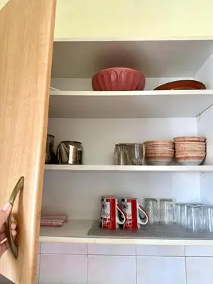 a cupboard with mugs and other dishes in it at Hay mohamedi in Oulad Akkou