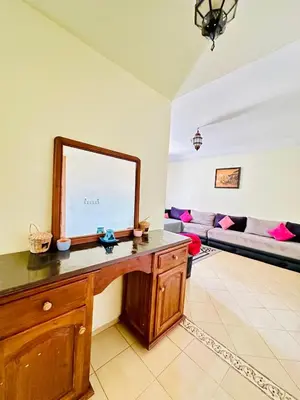 a living room with a table with a mirror at Hay mohamedi in Oulad Akkou