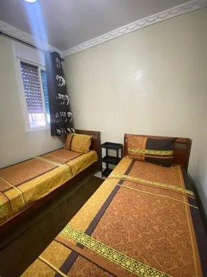 two beds and a couch in a room at Secure Beachfront Apartment Near Hilton Golf & Spa in Oulad Akkou