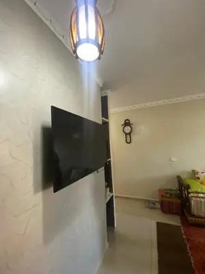 a flat screen tv hanging on a wall at Secure Beachfront Apartment Near Hilton Golf & Spa in Oulad Akkou