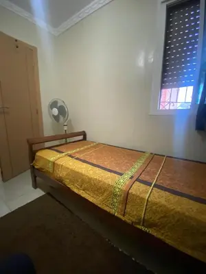 a bed sitting in a room with a window at Secure Beachfront Apartment Near Hilton Golf & Spa in Oulad Akkou