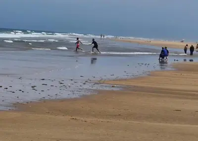 a group of people walking on the beach at Secure Beachfront Apartment Near Hilton Golf & Spa in Oulad Akkou