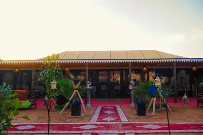 a building with a red rug in front of it at Sanmao Desert Luxury Camp in Merzouga