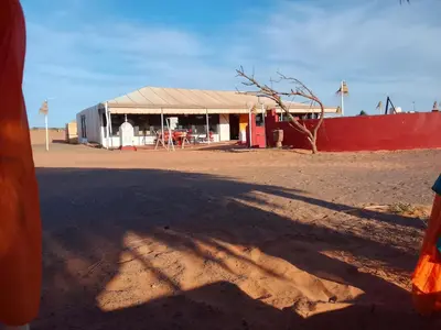 a building with a tent in the middle of a desert at hiya luxury camp in Merzouga