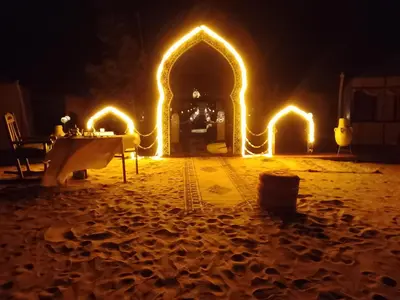 a table with lights on it in the sand at night at hiya luxury camp in Merzouga