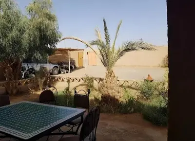 a table and chairs in the middle of a desert at hiya luxury camp in Merzouga