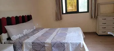 a bedroom with a bed and a dresser and a window at طريق تمصلوحت مراكش in Oulad Akkou