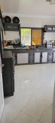 a kitchen with a counter top and a tile floor at طريق تمصلوحت مراكش in Oulad Akkou