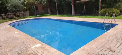 a large swimming pool with blue water at طريق تمصلوحت مراكش in Oulad Akkou