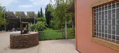 a building with a gate and a fence with a garden at طريق تمصلوحت مراكش in Oulad Akkou