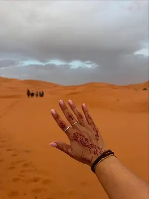 a woman with her hand in the desert at Glamping Under Stars in Merzouga
