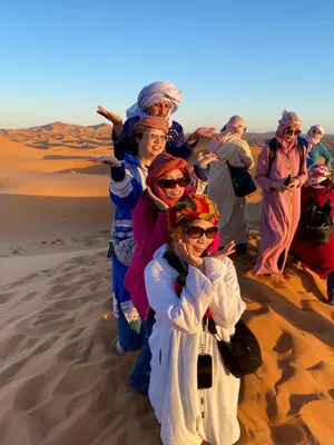 a group of women standing in the desert at Glamping Under Stars in Merzouga