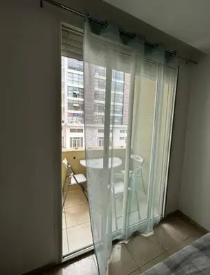 a room with a glass door with a table and a window at Ismail in Oulad Akkou