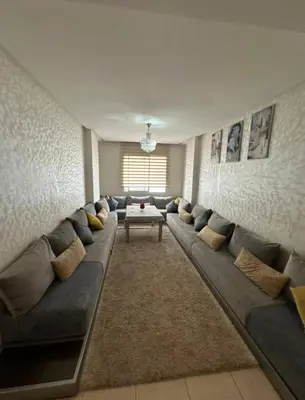 a living room with a long couch and a table at Ismail in Oulad Akkou