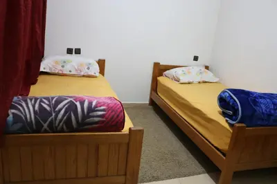 two twin beds in a room withthritisthritisthritisthritisthritisthritisthritisthritisthritis at Appartement juste pour les familles in Ifrane