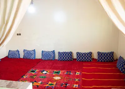 a room with a red carpet and blue pillows at berber discovery land