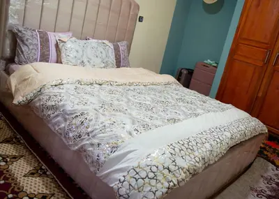 a bed with a white comforter and pillows on it at berber discovery land