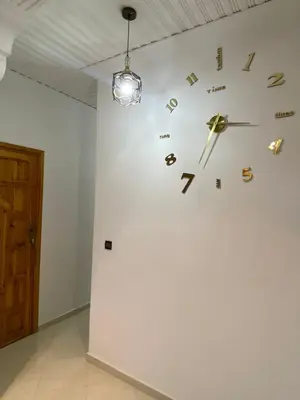 a clock on a wall in a room at Family Apartment in City Centre in Douar Oulad Mhammed